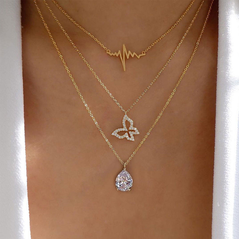 Crafted with multilayer gold-plated chains and detailed with pearl butterflies and a sun star pendant, this necklace makes a charming and timeless gift.