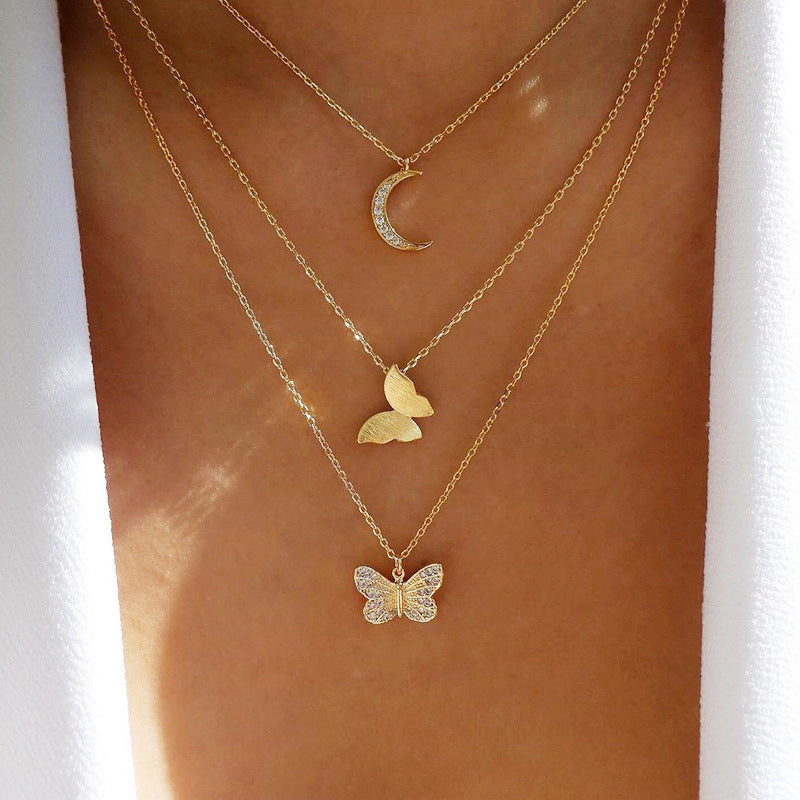 Crafted with multilayer gold-plated chains and detailed with pearl butterflies and a sun star pendant, this necklace makes a charming and timeless gift.