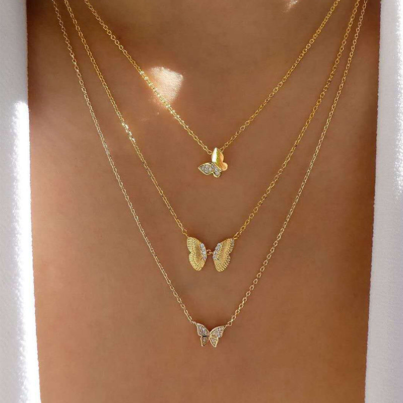 Crafted with multilayer gold-plated chains and detailed with pearl butterflies and a sun star pendant, this necklace makes a charming and timeless gift.